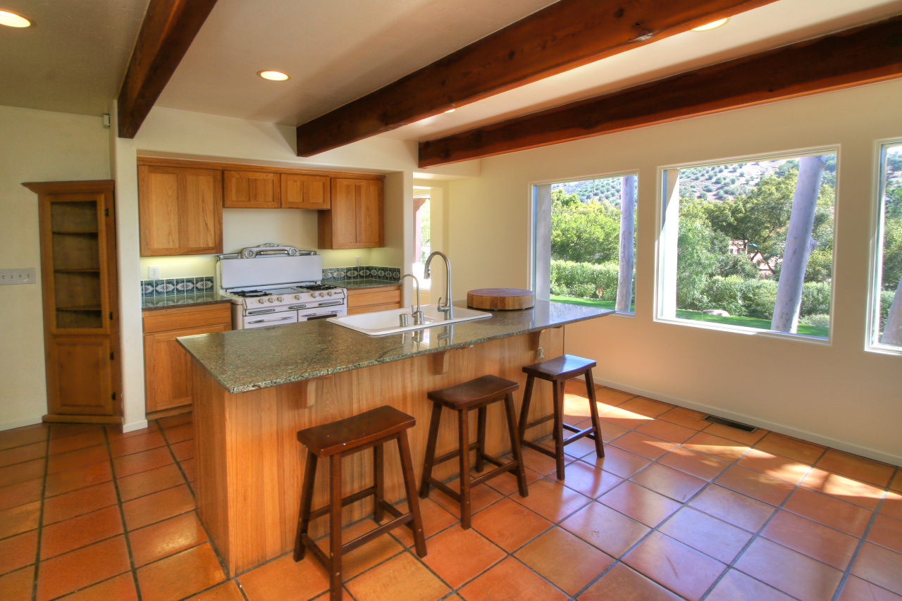 1331 Tunnel Road Santa Barbara, CA 93105 - Photo 13 of 22 a kitchen with a sink a stove and a dining table with kitchen view