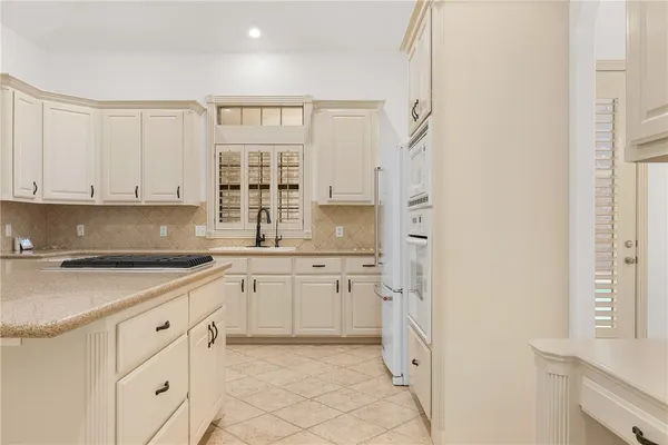 a kitchen with white cabinets and white appliances