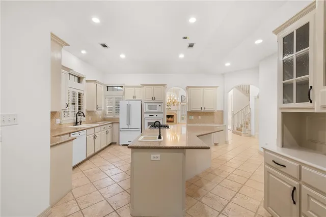 a large kitchen with kitchen island a sink stainless steel appliances and cabinets