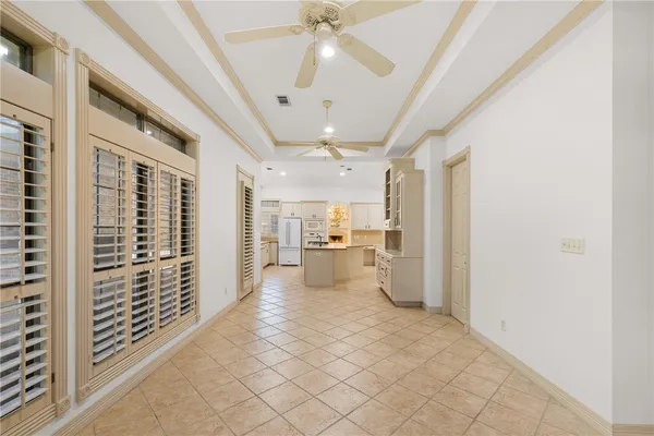 a view of a hallway with wooden floor and a kitchen