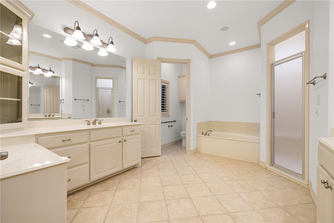 5011 Fairfield Court Bryan, TX 77802 - Photo 24 of 46 a spacious bathroom with a granite countertop sink a toilet a mirror and bathtub