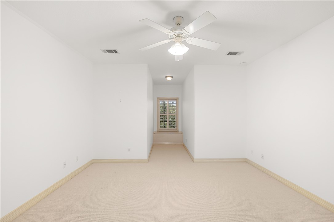 5011 Fairfield Court Bryan, TX 77802 - Photo 32 of 46 an empty room with a ceiling fan and a window