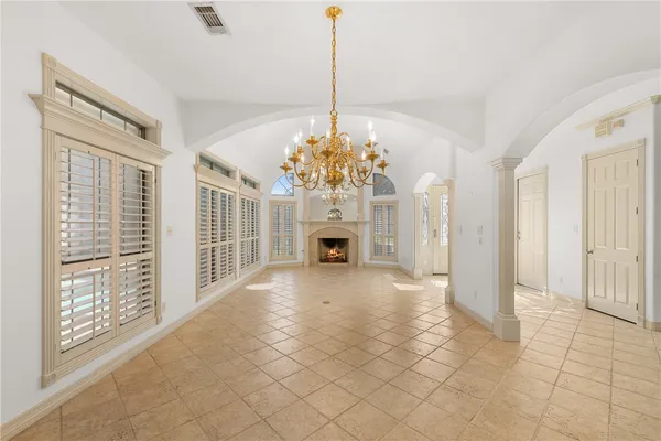 a view of a livingroom with a chandelier curtains and large windows