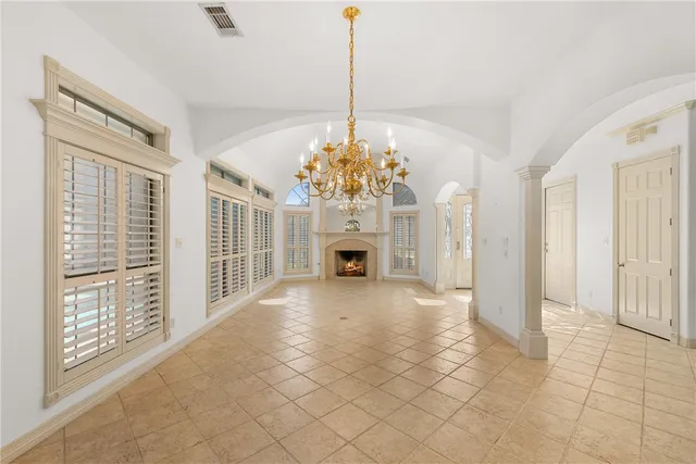 a view of a livingroom with a chandelier curtains and large windows