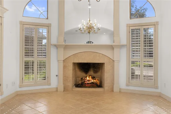 a view of a livingroom with a chandelier fan and a fireplace