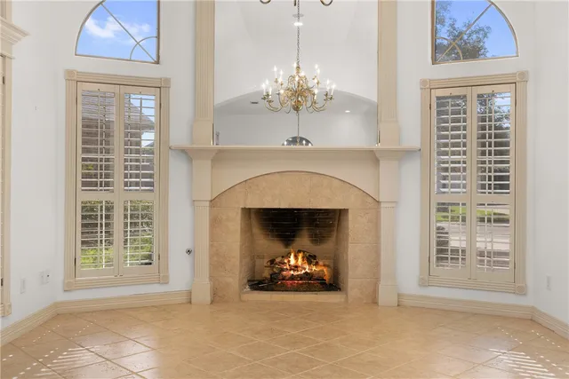 a view of a livingroom with a chandelier fan and a fireplace