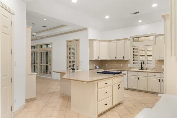 a kitchen with white cabinets and sink