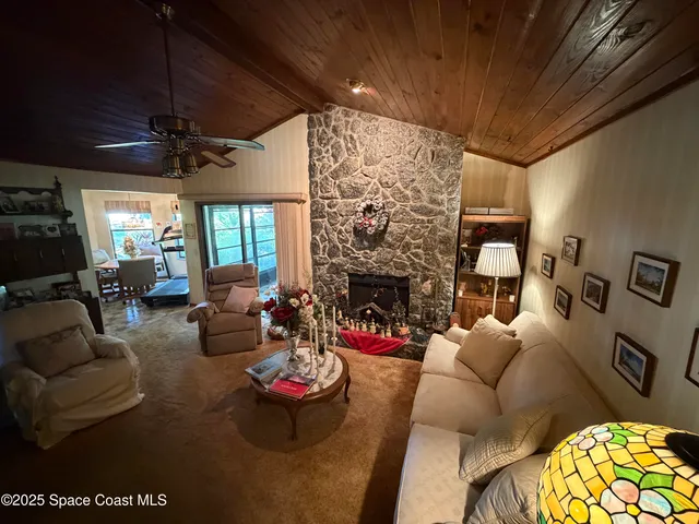 a living room with furniture a fireplace and a chandelier