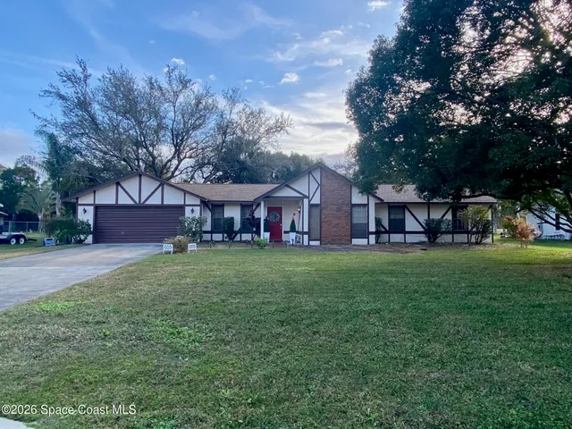 a view of house with outdoor space and garden