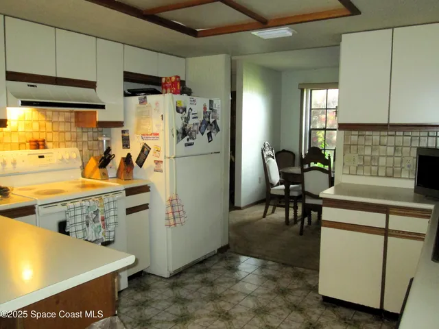 a view of a kitchen with fridge and workspace