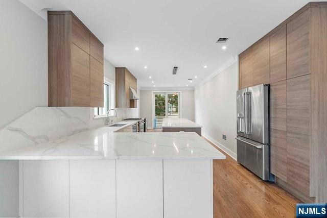 211 Warwick Avenue, Unit 1 Fort Lee, NJ 07024 - Photo 14 of 43 a large kitchen with stainless steel appliances a large counter top a stove and a refrigerator