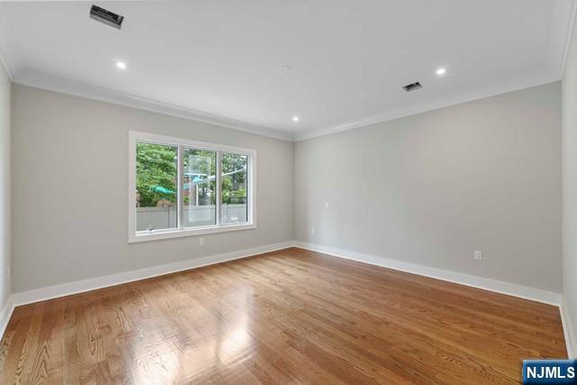 211 Warwick Avenue, Unit 1 Fort Lee, NJ 07024 - Photo 15 of 43 an empty room with wooden floor and windows