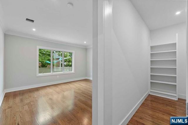 211 Warwick Avenue, Unit 1 Fort Lee, NJ 07024 - Photo 19 of 43 a view of an empty room with a window and wooden floor