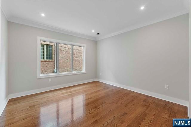 211 Warwick Avenue, Unit 1 Fort Lee, NJ 07024 - Photo 26 of 43 a view of an empty room with wooden floor and a window