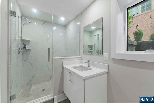 211 Warwick Avenue, Unit 1 Fort Lee, NJ 07024 - Photo 37 of 43 a bathroom with a sink a mirror and shower