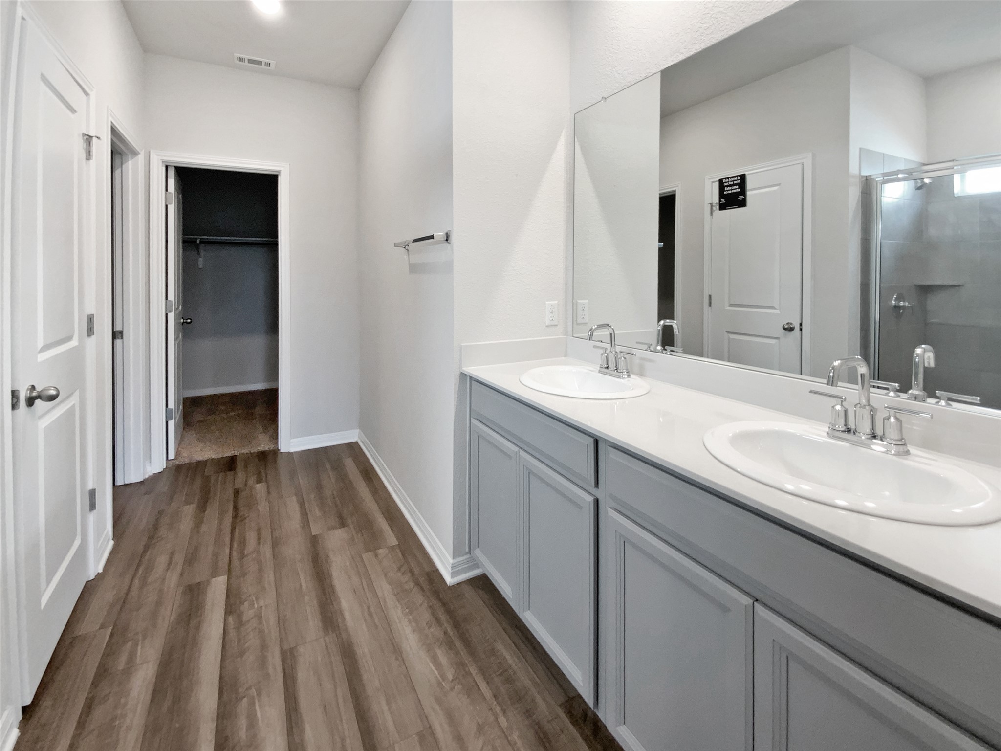 220 Sungrove Trail Georgetown, TX 78628 - Photo 7 of 23 Bathroom with a stall shower, double vanity, dark wood-style floors, and a spacious closet