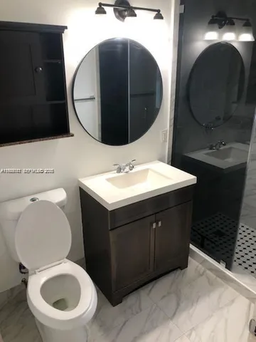 a bathroom with a toilet mirror and sink