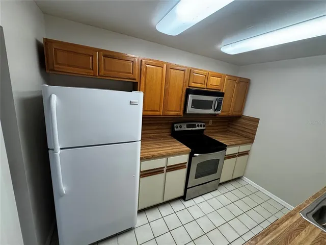 a refrigerator freezer and a stove sitting inside of a kitchen