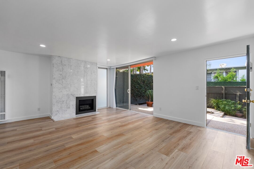122 Buccaneer Street, Unit 1 Marina del Rey, CA 90292 - Photo 1 of 21 a view of empty room with wooden floor and fireplace