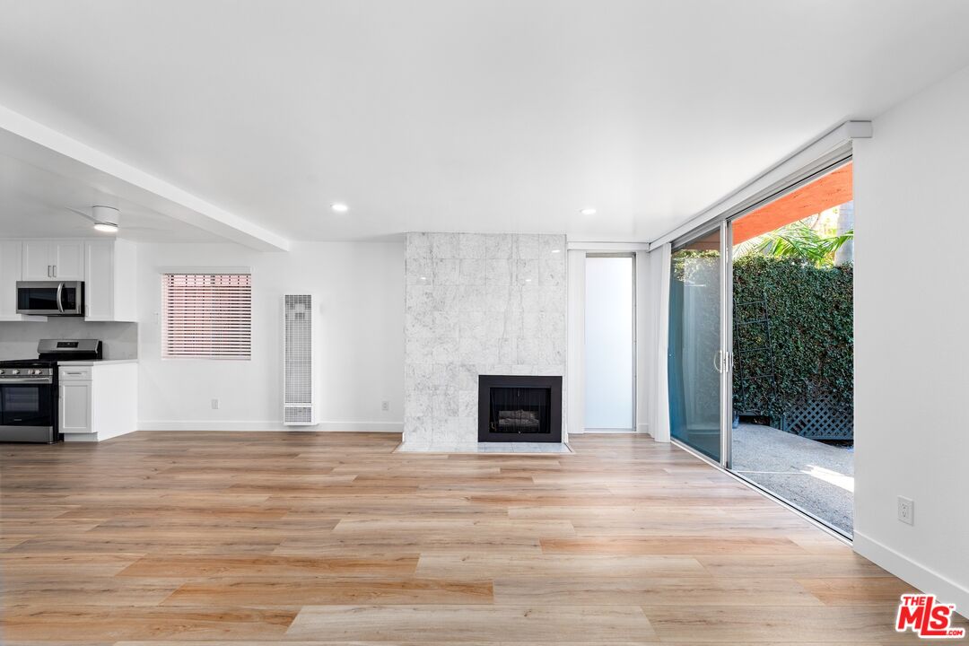 122 Buccaneer Street, Unit 1 Marina del Rey, CA 90292 - Photo 5 of 21 a view of empty room with wooden floor and fireplace