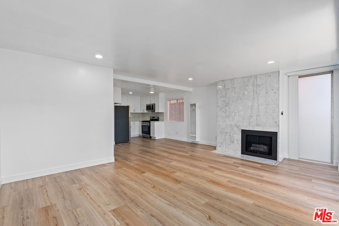 122 Buccaneer Street, Unit 1 Marina del Rey, CA 90292 - Photo 7 of 21 a view of a livingroom with a fireplace wooden floor and window