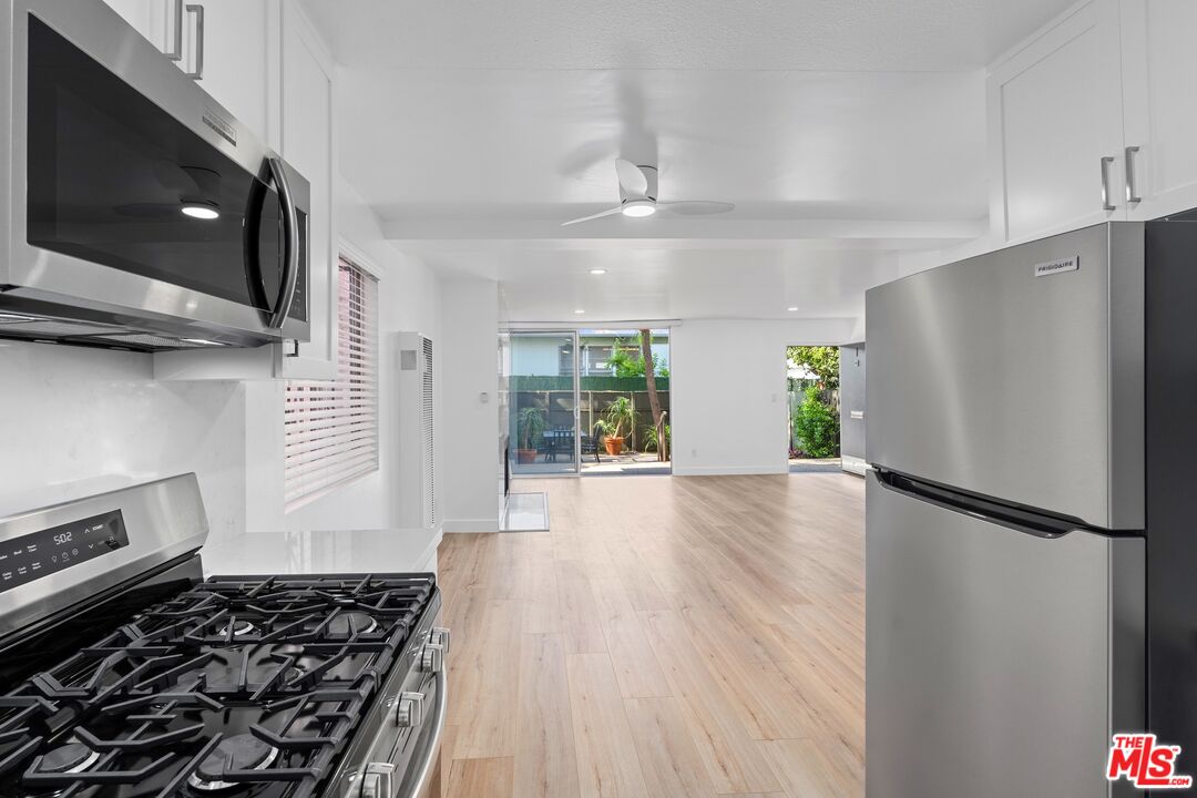 122 Buccaneer Street, Unit 1 Marina del Rey, CA 90292 - Photo 9 of 21 a kitchen with stainless steel appliances granite countertop a refrigerator and a stove top oven
