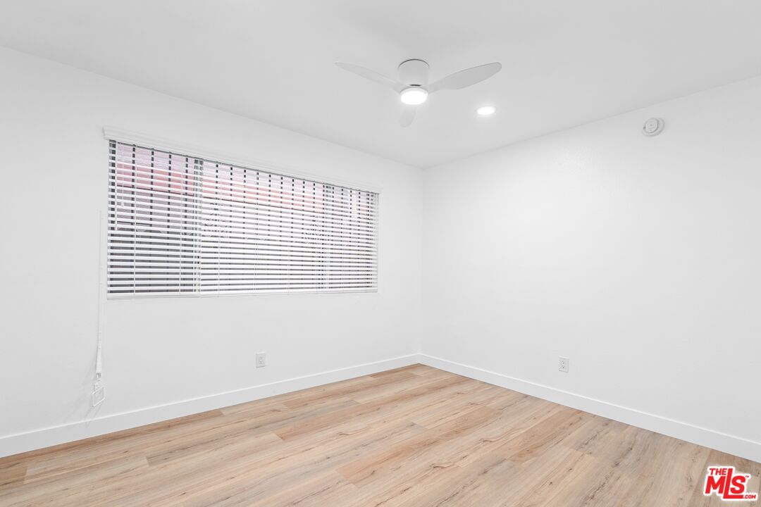 122 Buccaneer Street, Unit 1 Marina del Rey, CA 90292 - Photo 10 of 21 a view of an empty room with wooden floor and a window