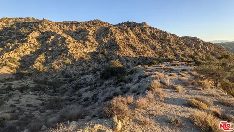 a view of a large building with mountains in the background