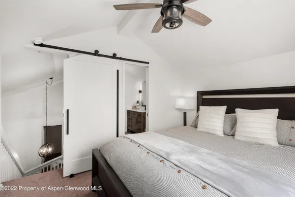 a bedroom with a bed and a mirror