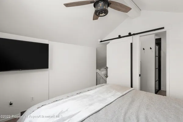 a bedroom with a bed and a flat tv screen