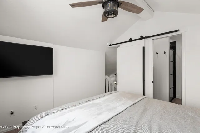 a bedroom with a bed and a flat tv screen