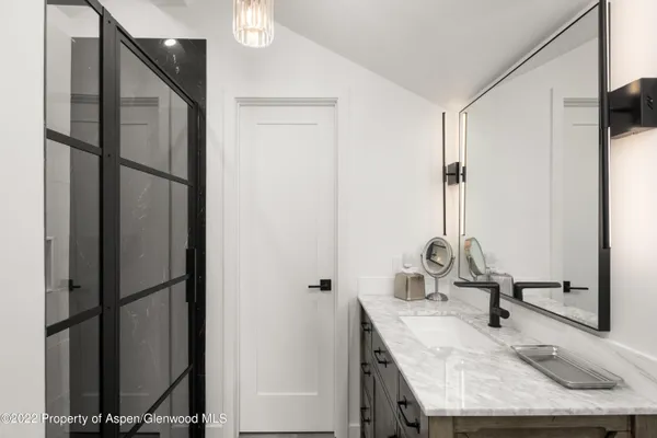 a bathroom with a granite countertop sink and a mirror