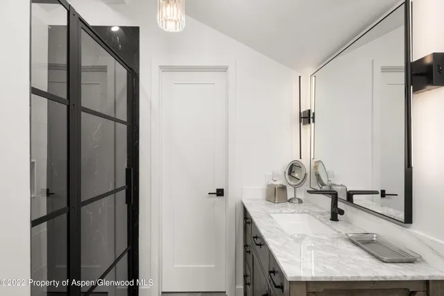 a bathroom with a granite countertop sink and a mirror