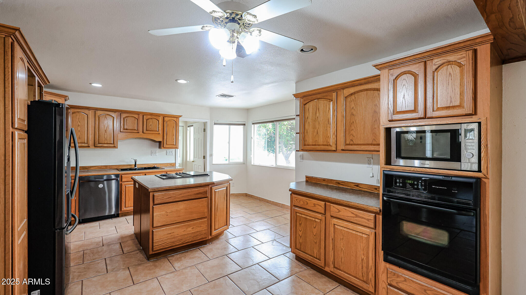 11851 North Thunderbird Road Sun City, AZ 85351 - Photo 10 of 46 a kitchen with stainless steel appliances granite countertop a stove top oven microwave and refrigerator