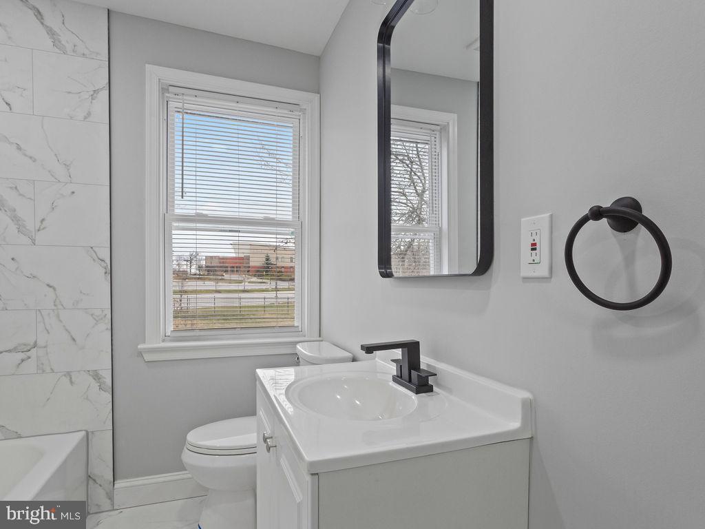 5716 Leith Walk Baltimore, MD 21239 - Photo 17 of 36 a bathroom with a toilet a sink and mirror