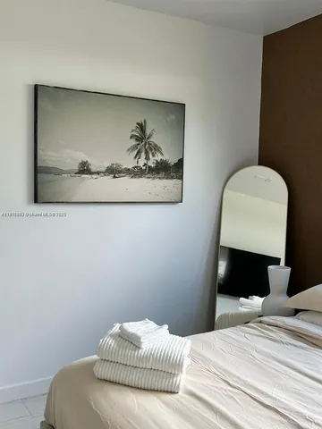 a bedroom with a bed and a wall painting