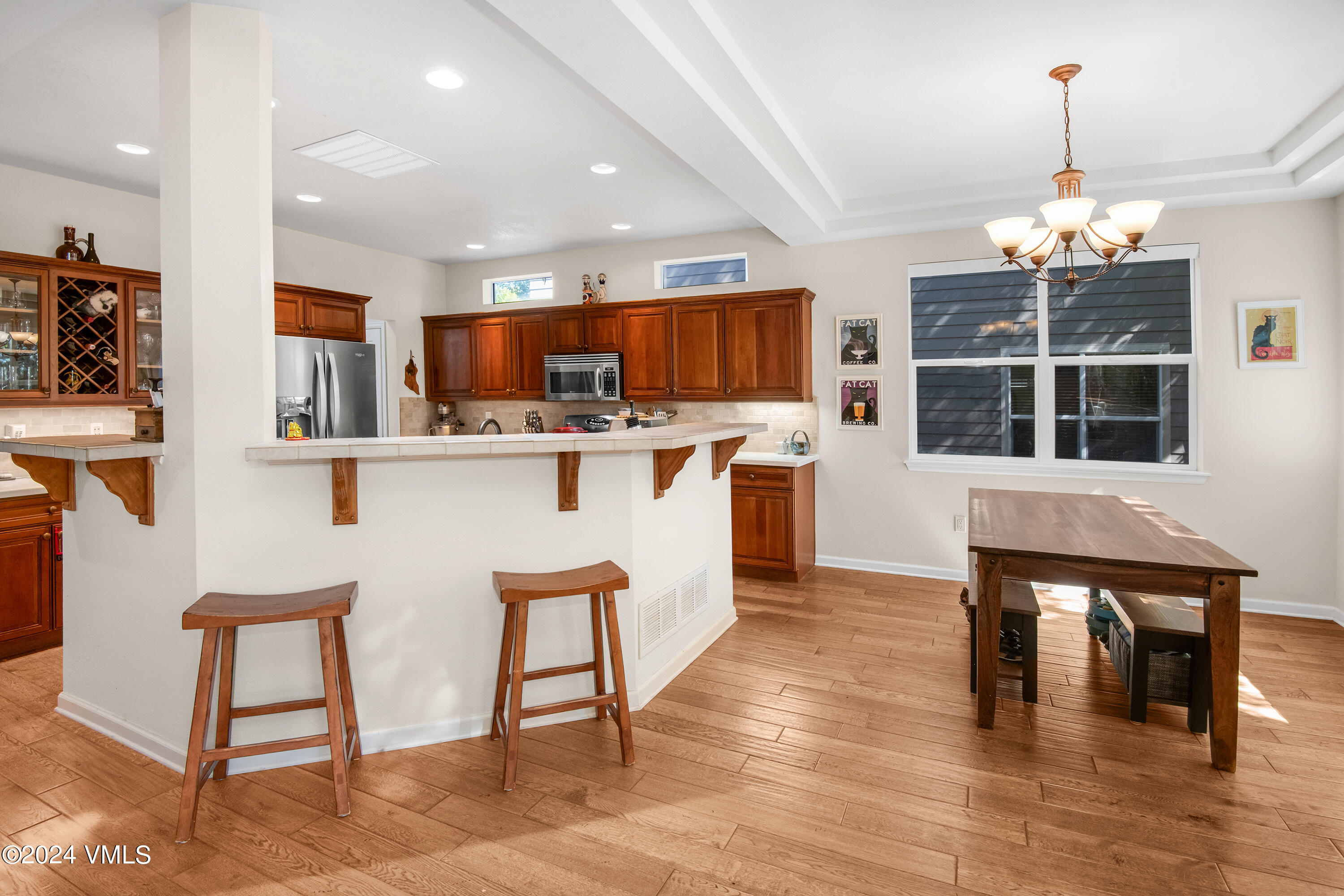 216 Mayer Street Eagle, CO 81631 - Photo 9 of 51 a kitchen with stainless steel appliances granite countertop a stove top oven a refrigerator a dining table and chairs with wooden floor