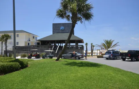a front view of a building with cars parked