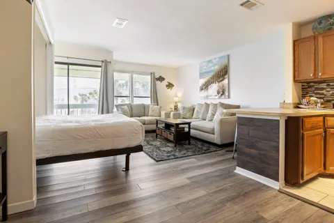 a spacious bedroom with a bed a couch and large windows