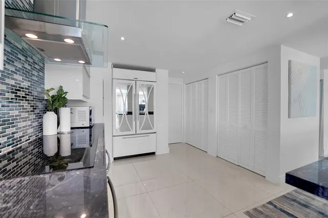 a kitchen with stainless steel appliances a stove and white cabinets