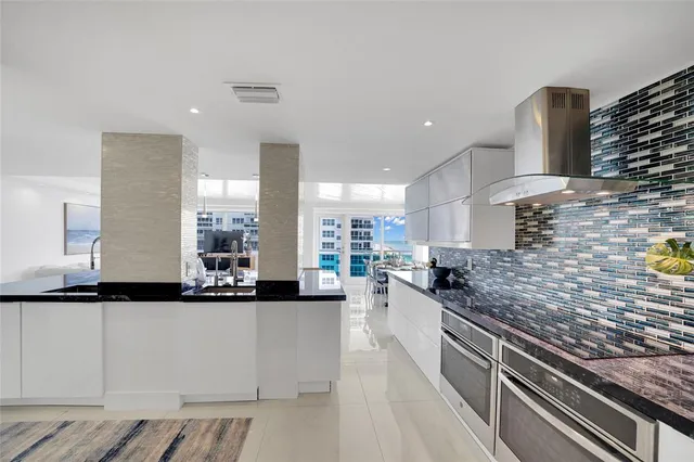 a kitchen with stainless steel appliances granite countertop a sink a stove and a refrigerator