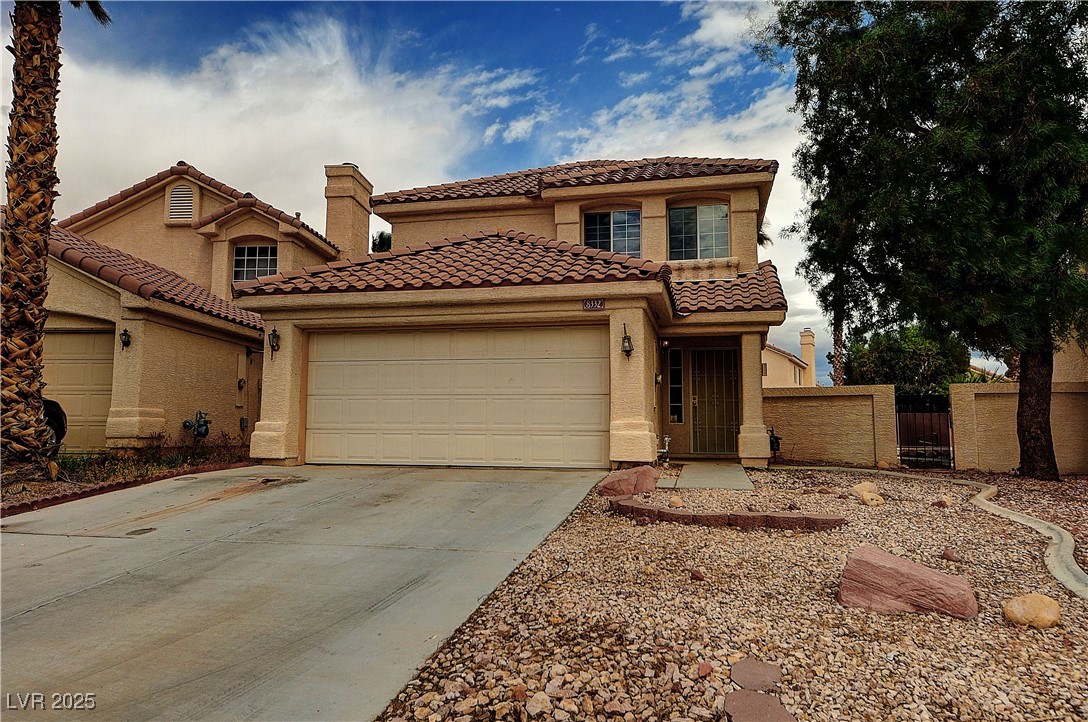 Mediterranean / spanish home with stucco siding, a tiled roof, concrete driveway, and an attached garage