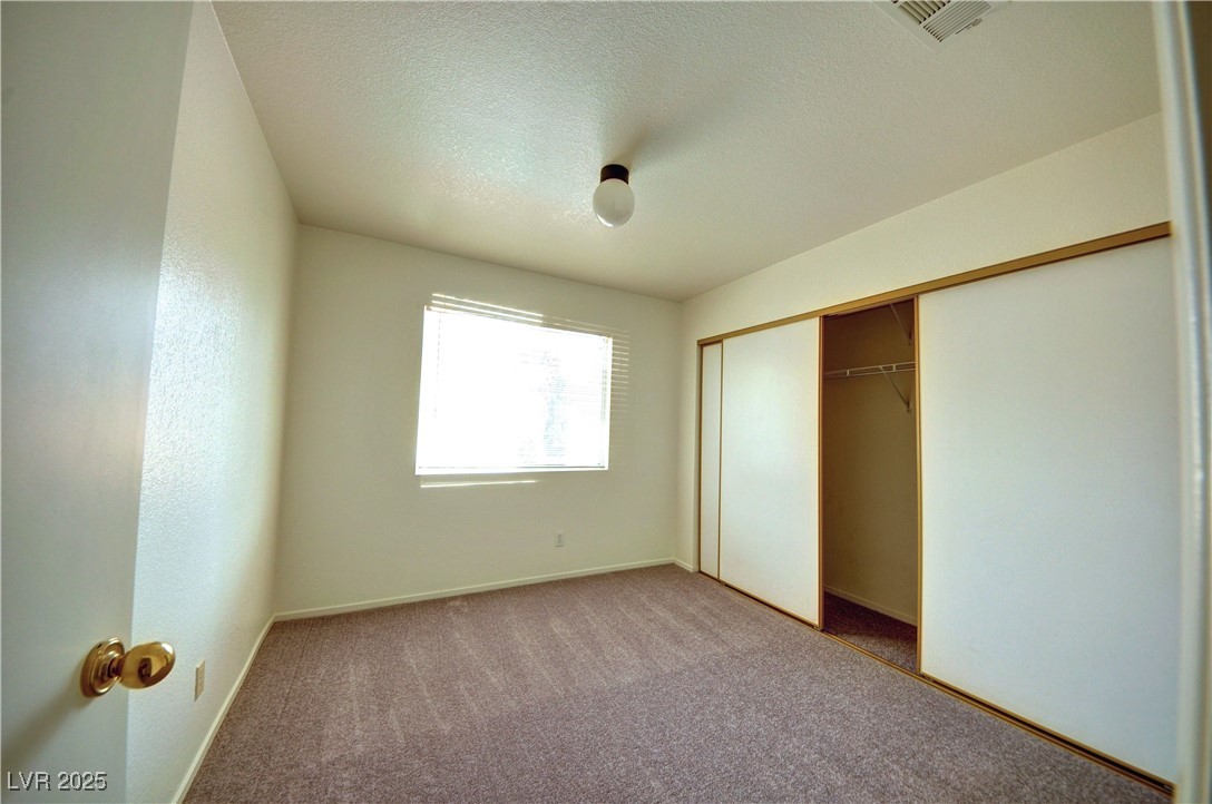 8332 Monico Valley Court Las Vegas, NV 89128 - Photo 10 of 14 Unfurnished bedroom featuring carpet flooring, a textured ceiling, and a closet