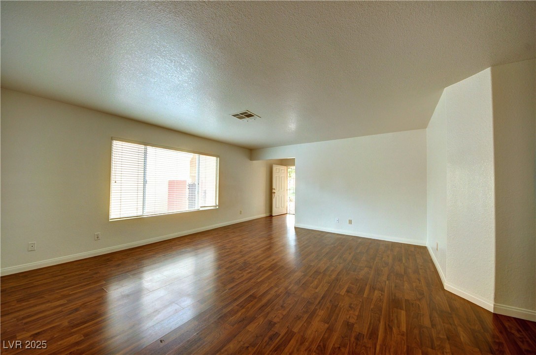 8332 Monico Valley Court Las Vegas, NV 89128 - Photo 3 of 14 Empty room featuring a textured ceiling and dark wood-style floors