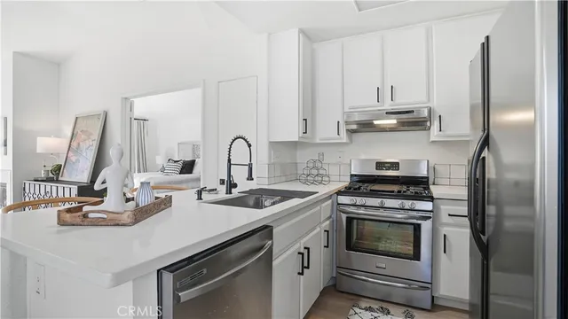 a kitchen with stainless steel appliances a stove a sink and cabinets