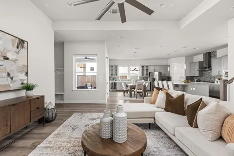 a living room with furniture kitchen view and a large window