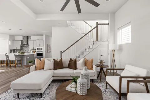 a living room with furniture and a view of kitchen