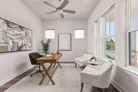 a view of a workspace with furniture and a window