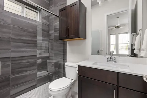 a bathroom with a sink a toilet and shower