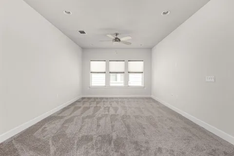an empty room with a window and a ceiling fan